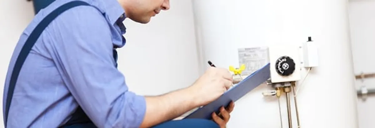 Water heater repair technician inspecting the unit and recording service notes in Dayton, OH